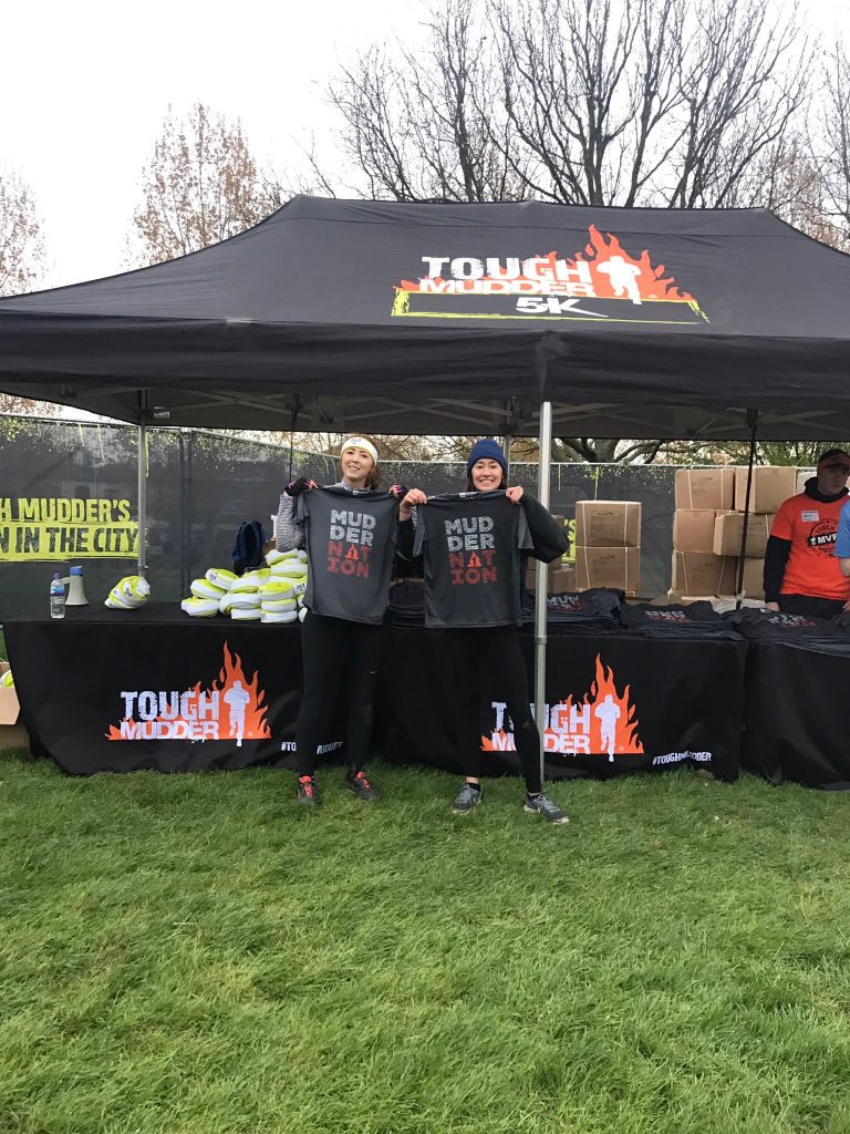 Mollie Benjamin and Caro Lobsang from Bolt Burdon Kemp holding up their Tough Mudder t-shirts