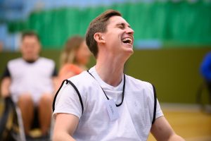 Joshua Hughes playing wheelchair rugby smiling