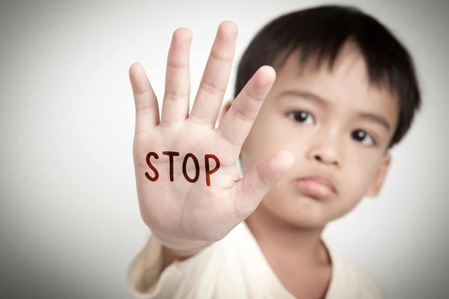 Sad,Face,Of,Asian,Kid,And,Hand,Raise,Stop,Written