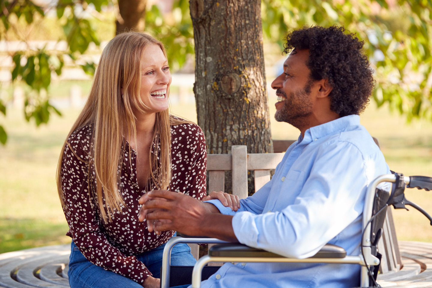 Mature,Couple,With,Man,Sitting,In,Wheelchair,Talking,In,Park