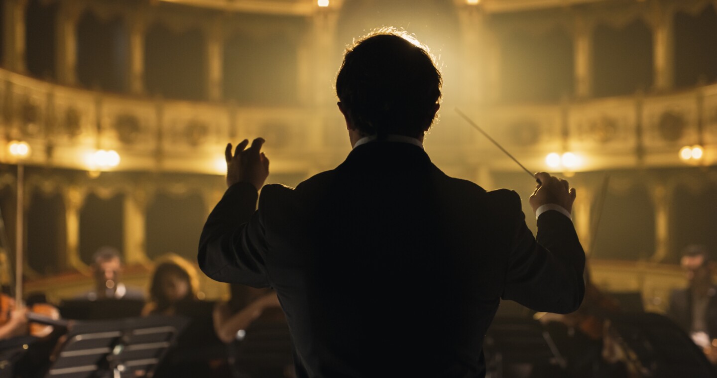 Back,View,Cinematic,Shot,Of,Conductor,Directing,Symphony,Orchestra,With